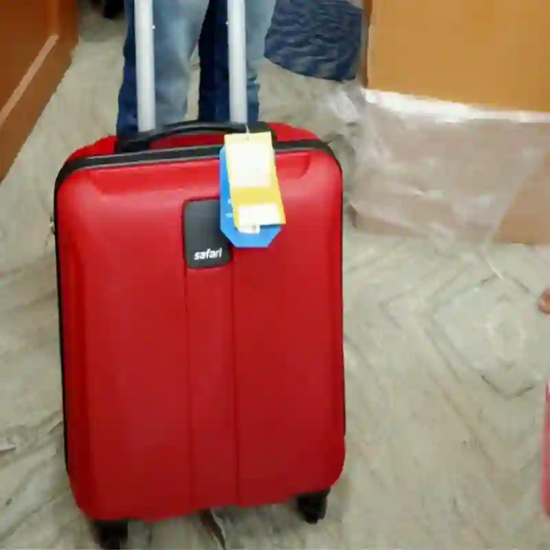 A 55cm cabin trolley bag being carried onto an Indian train, showing its compact size for solo travel