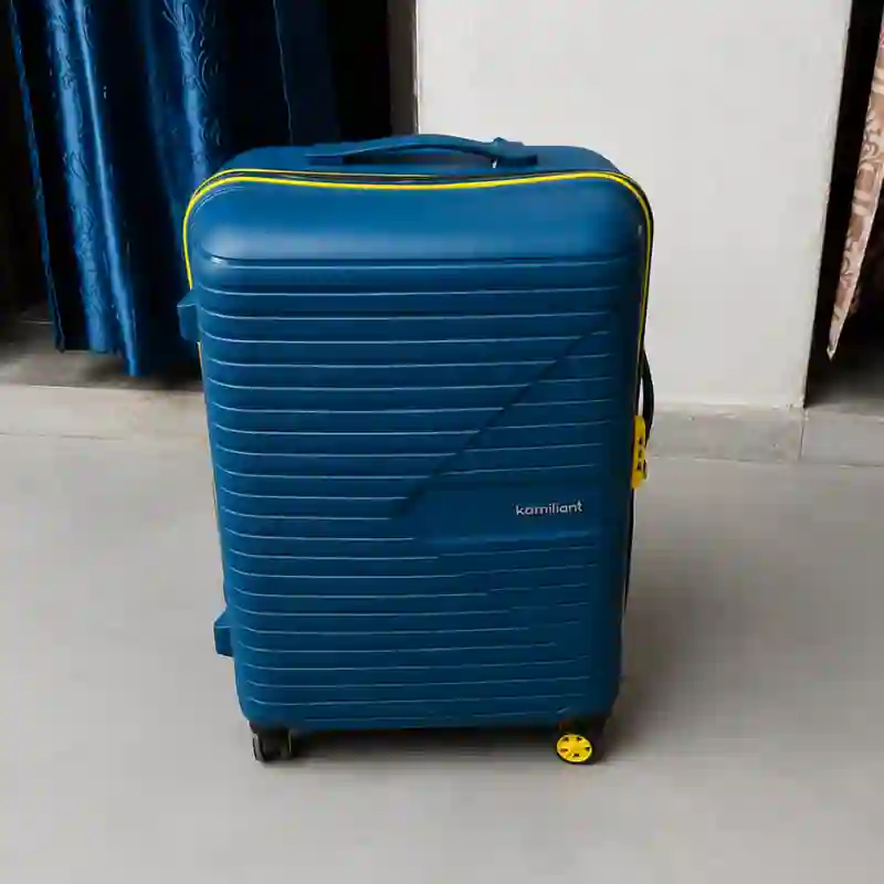 Traveller using a hard-shell suitcase at an airport